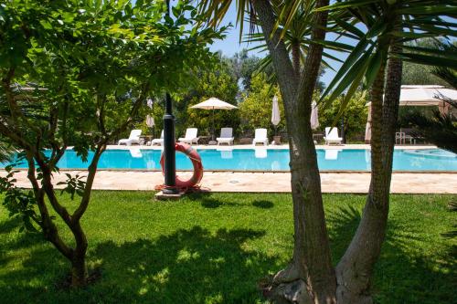 una piscina con un tobogán rojo junto a un complejo en Trulli Boccadoro, en Ostuni