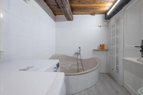 een witte badkamer met een bad en een wastafel bij Véritable Mas Provençal À La Palud in La Palud sur Verdon