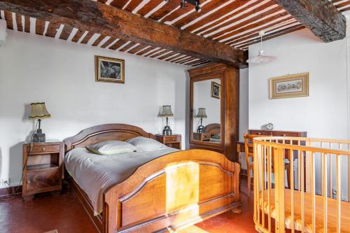 a bedroom with a wooden bed and a wooden staircase at Véritable Mas Provençal À La Palud in La Palud sur Verdon