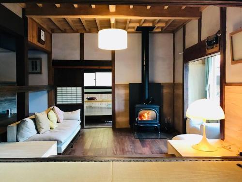 sala de estar con sofá y chimenea en ビラ里山双林, en Inashiki