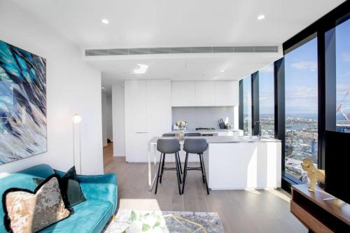 een open keuken en een woonkamer met een blauwe bank bij Stunning City Views 2 bed 2 bath- Ur Urban Oasis！ in Melbourne