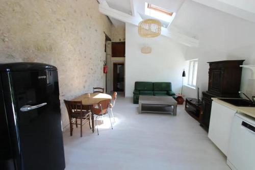 a kitchen and a living room with a black refrigerator at La Bastide De Queyran in La Palud sur Verdon