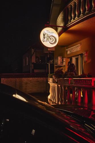 a sign hanging from the side of a building at night at Tokajer Wellness Panzió in Keszthely