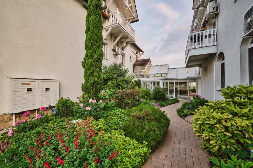 a brick walkway in front of a building with flowers at Tokajer Wellness Panzió in Keszthely
