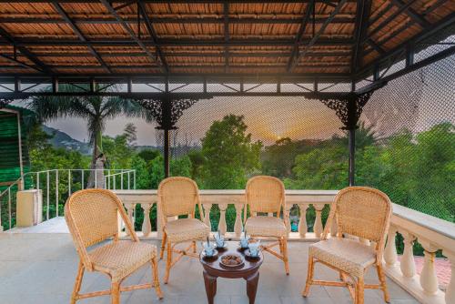 a group of chairs and a table on a patio at SaffronStays Grandiosa - 4 BDR pet-friendly, pool villa Khandala in Khandala