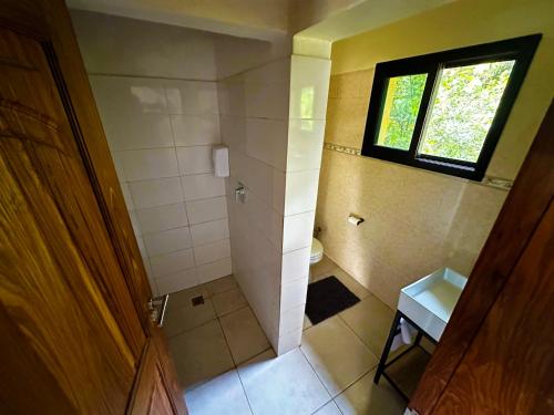 a small bathroom with a shower and a window at BOUGAINVILLA Boutique Hotel & Restaurant in Lubumbashi