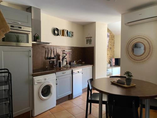 une cuisine avec une machine à laver et une table dans l'établissement Le Grenache, à Collioure