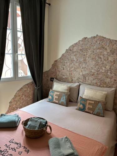 - un lit avec des oreillers et un panier dans l'établissement Le Grenache, à Collioure