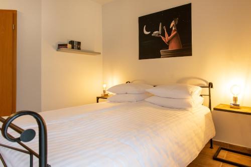 a bedroom with a bed with white sheets and pillows at Landhotel Teichwiesenhof in Oldenburg in Holstein