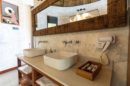 a bathroom with a sink and a phone on a counter at Sundiata Beach Resort in Entebbe