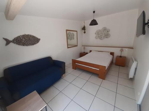 une chambre avec un lit et un canapé bleu dans l'établissement petite maison de campagne gardoise, à Théziers