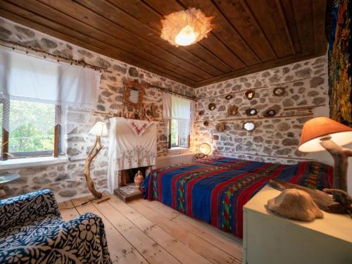 1 dormitorio con 1 cama en una habitación con paredes de piedra en Σαν Παραμύθι, en Filýra