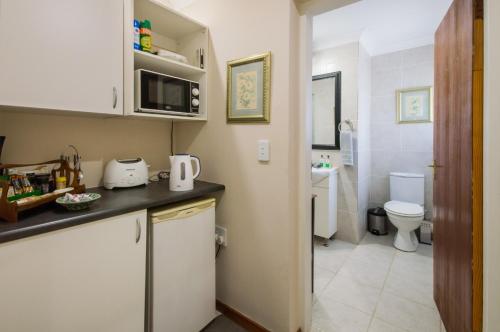 eine kleine Küche mit einem Waschbecken und einem WC in der Unterkunft Golfer's Lodge in Edenvale
