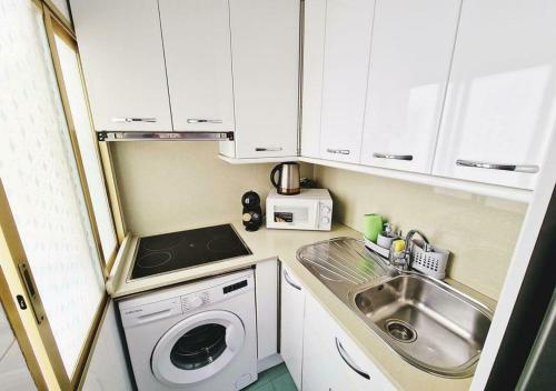 a small kitchen with a sink and a washing machine at Carmen Apartments in Benidorm