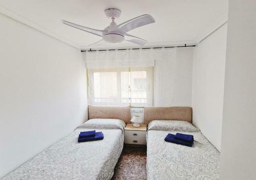 a bedroom with two beds and a ceiling fan at Carmen Apartments in Benidorm