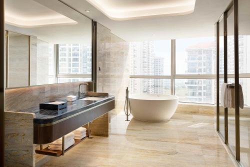 a bathroom with a tub and a large window at Sheraton Zhanjiang Hotel in Zhanjiang