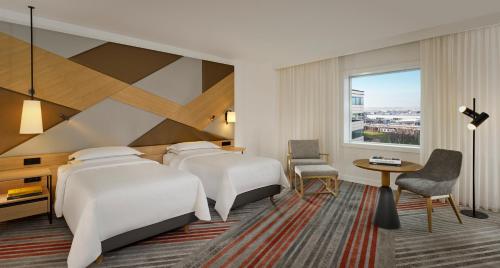 a hotel room with two beds and a window at Sheraton Amsterdam Airport Hotel and Conference Center in Schiphol