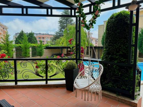 balcón con 2 sillas y vistas al jardín en Family Hotel Paradise, en Saints Constantine and Helena