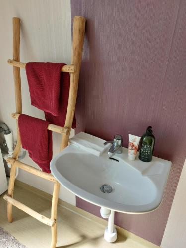 La salle de bains est pourvue d'un lavabo blanc et d'une chaise. dans l'établissement Flora Dekor gästgård, Lenagården, à Alingsås