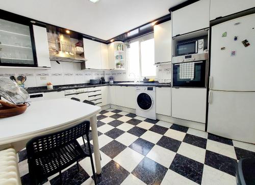 una cocina con suelo a cuadros en blanco y negro en Apartamento céntrico y luminoso cerca de la playa. en Castellón de la Plana