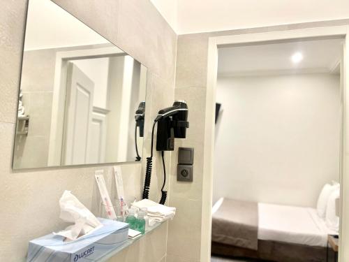 a bathroom with a phone on a wall next to a mirror at Villa Berlioz in Nice