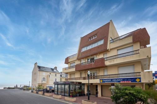 a building on the side of a street at Un Balcon sur la Mer - Appt à 30m de la plage in Saint-Aubin-sur-Mer