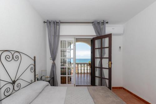 a bedroom with a bed and a view of the ocean at Casa Siloam in Torrox Costa