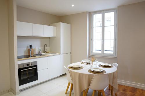 a kitchen with a table with chairs and a window at Appart Lumineux 150 m de la Gare in Bourg-en-Bresse