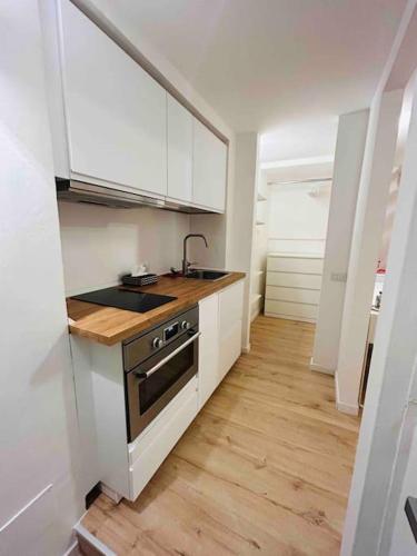 a kitchen with white cabinets and a sink and a stove at Studio Apartment Near Bocconi in Milan