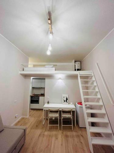 a small apartment with a staircase and a table in a room at Studio Apartment Near Bocconi in Milan