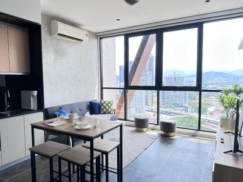 a kitchen and living room with a table and a large window at Infinity Pool Scarletz Suites KLCC in Kuala Lumpur