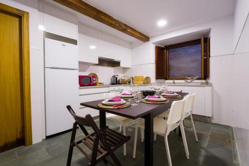 a dining room with a table and chairs in a kitchen at Casa D'Abaixo in Arzúa