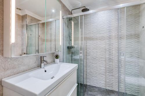 y baño con lavabo y ducha acristalada. en Hanami Puerto Alto PA 1-6, en Estepona
