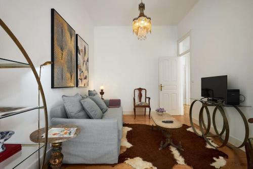 ein Wohnzimmer mit einem Sofa und einem Tisch in der Unterkunft Charming Lisbon Central Apartment in Lissabon