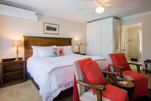 a bedroom with a large bed and two chairs at Golfer's Lodge in Edenvale
