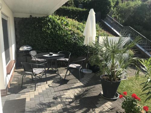 a patio with a table and chairs and an umbrella at FeWo Oase Ruhrtalblick in Bestwig