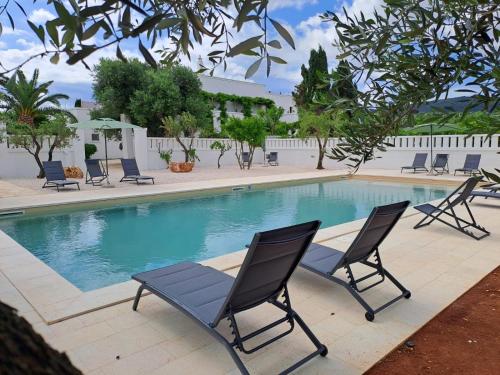 a swimming pool with two chairs and a table at Masseria Parco di Castro in Montalbano