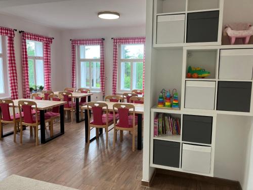 a dining room with tables and chairs and windows at Penzion Hají in Janov nad Nisou