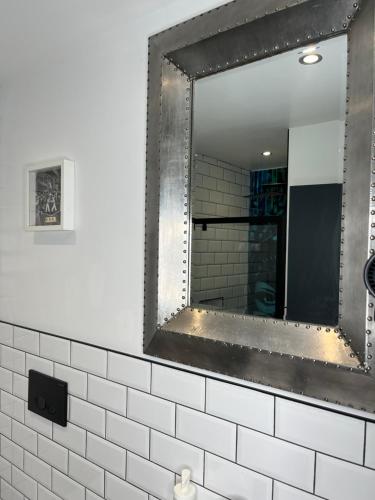 a mirror on a wall in a bathroom at Duplex Apartment Harbourside city centre in Bristol