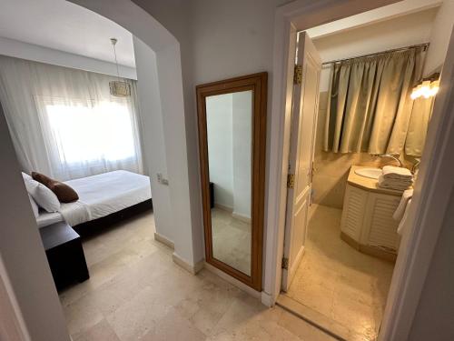 a bathroom with a mirror and a bedroom with a bed at GS 18 Villa in Hurghada