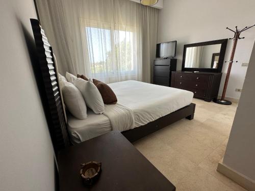a bedroom with a bed with a mirror and a table at GS 18 Villa in Hurghada