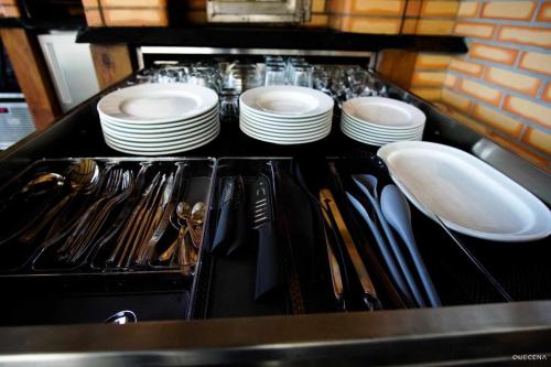 a kitchen with plates and utensils on a counter at Currais o pequeno paraíso entre o mar e a serra in Aveiro