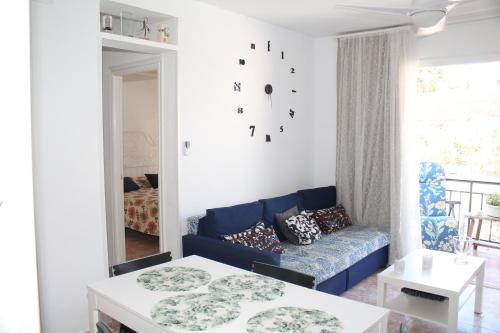 een woonkamer met een blauwe bank en een tafel bij Apartamento Carlota beach carihuela in Torremolinos