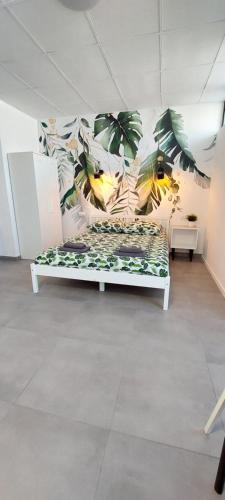 a bed in a room with a mural of plants at Apartamenty Częstochowa in Częstochowa