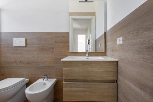 een badkamer met een wastafel, een toilet en een spiegel bij Villa La Quiete by BarbarHouse in Copertino