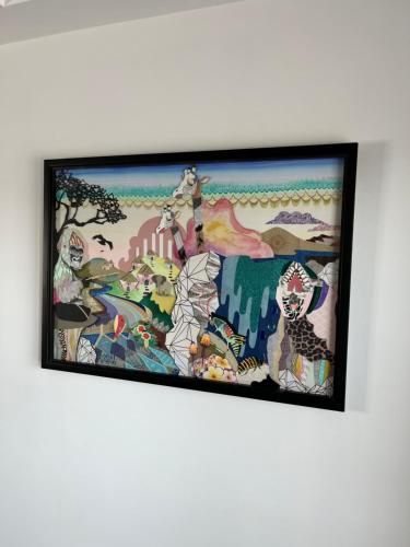 a painting hanging on a white wall at Duplex Apartment Harbourside city centre in Bristol