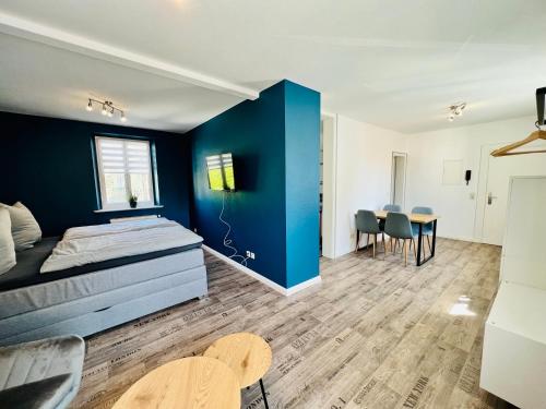 Schlafzimmer mit einer Wand mit blauen Akzenten und einem Tisch in der Unterkunft BlueLagoon in Schweinfurt