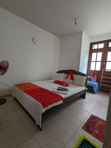 Un dormitorio con una cama con una manta roja. en Shiranthi Guest House, en Rajagiriya