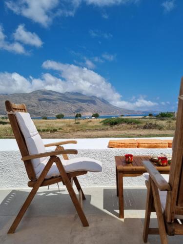 une chaise et une table sur une terrasse avec vue dans l'établissement All Season Lovely Seafront Cottage, à Kíssamos