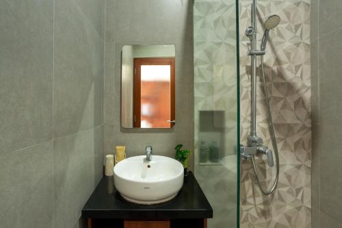 uma casa de banho com um lavatório e um chuveiro em Cove Ransha Stay em Sanur